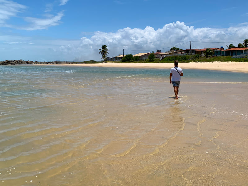 Homem caminha pelo mar raso de Camurupim, mais uma dica de o que fazer em Natal