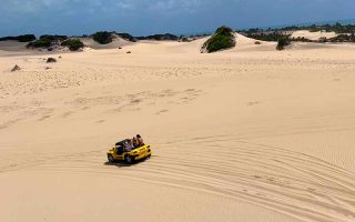 Buggy amarelo anda pelas Dunas de Genipabu, em Natal