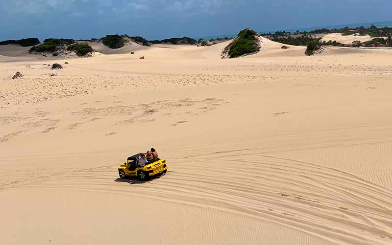 Buggy amarelo anda pelas Dunas de Genipabu, em Natal