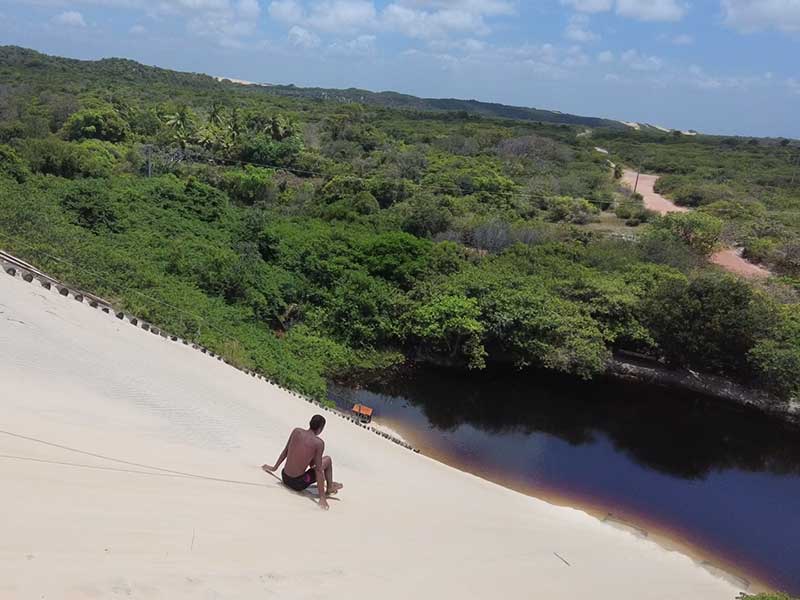 Homem escorrega em duna na Lagoa de Jacumã, Rio Grande do Norte