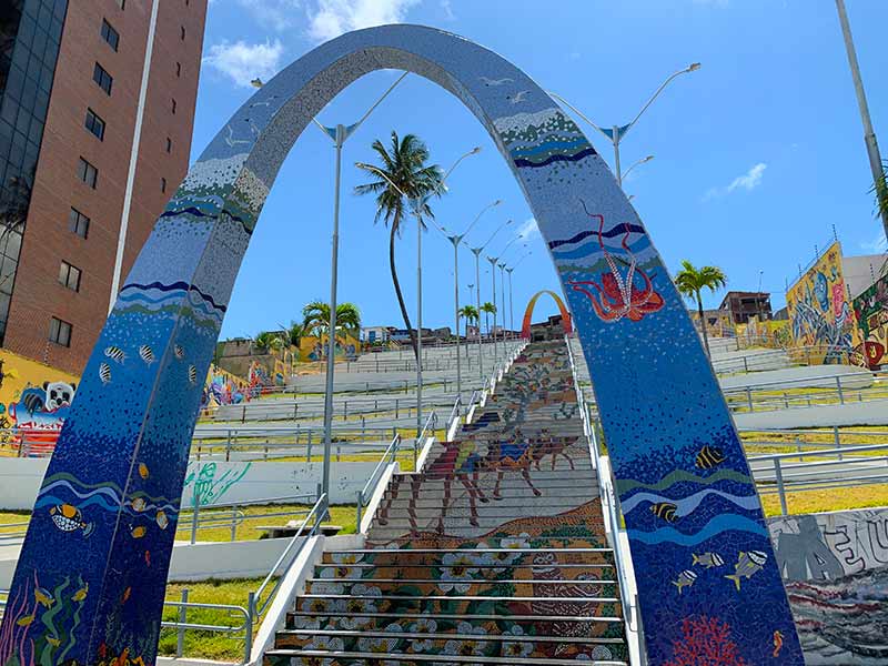 Escadaria Mãe Luiza, dica de o que fazer em Natal, com grafites em dia de céu azul