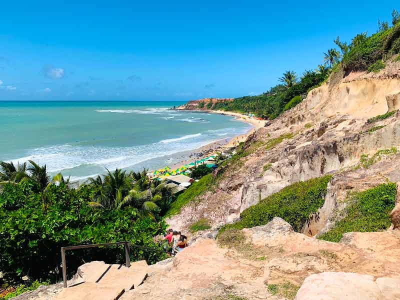 Praia do Amor vista de cima em Pipa com falésias e guarda-sóis na areia