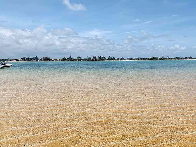 Barco em águas cristalinas de Areia Vermelha em João Pessoa