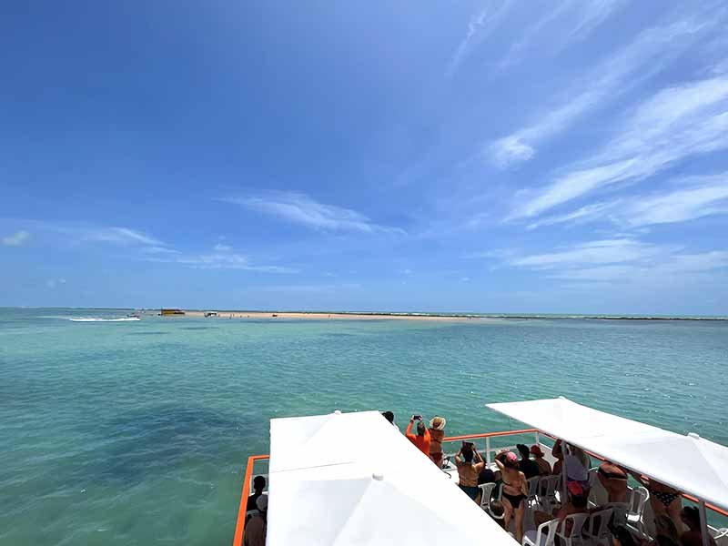 Barco chegando com turistas na ilha de Areia Vermelha, em João Pessoa