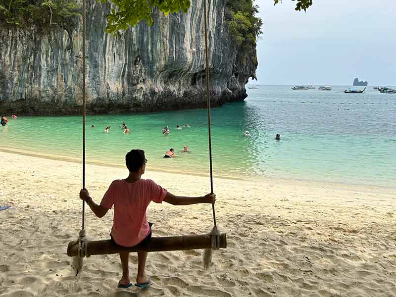 Homem sentado em balanço em Hong Island, pertinho de Railay Beach