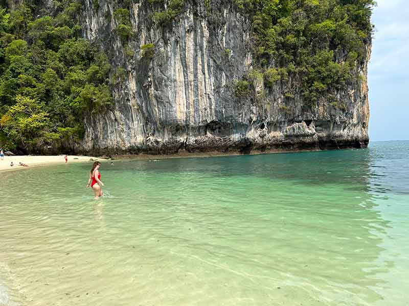 Mulher de maiô vermelho entra nas águas da Hong Island, na Tailândia