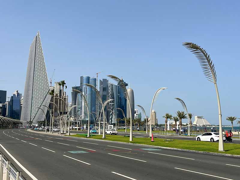 Vista da orla do Corniche em Doha com prédios e rua vazia