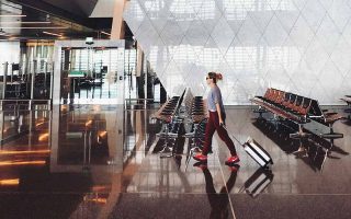 Mulher com mala no aeroporto a caminho da imigração em Doha, Qatar