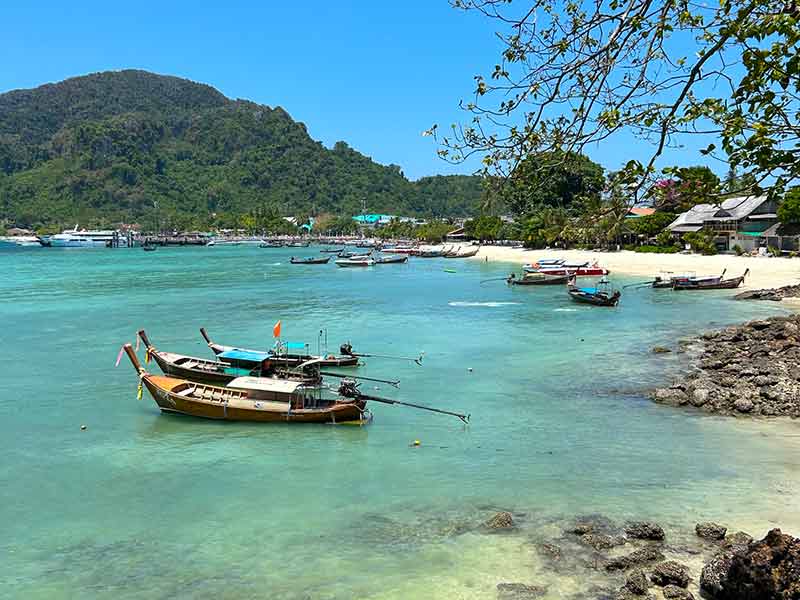 Barco no mar esverdeado de Phi Phi, na Tailândia