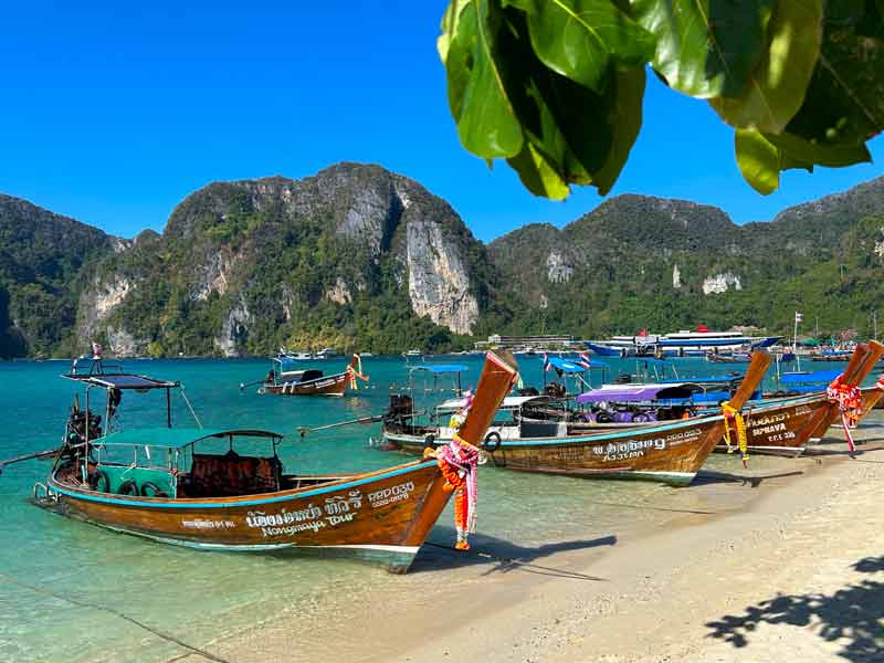 Barcos no mar de Tonsai Bay, dica de o que fazer em Phi Phi, em dia de céu azul