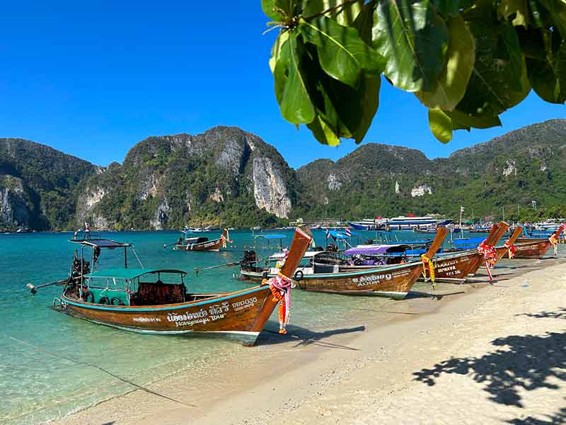 Barcos parados no mar de Koh Phi Phi, na Tailândia, em dia de céu azul