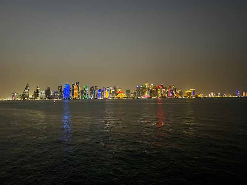 Prédios de Doha iluminados à noite no Mina District, dica do que fazer em conexão em Doha