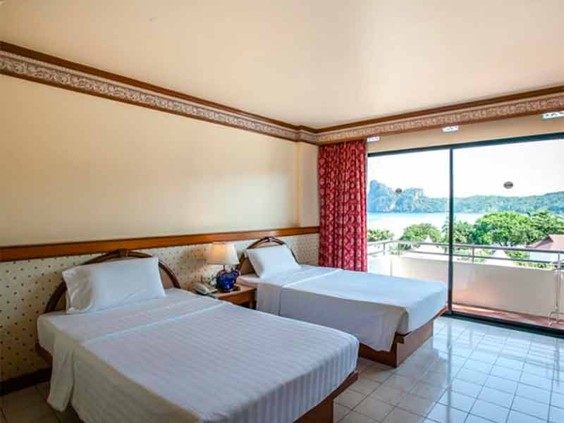 Quarto simples do Phi Phi Hotel com duas camas de solteiro e varanda