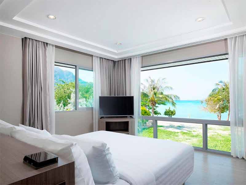 Quarto com decoração clara do P. P. Princess, dica de onde ficar em Phi Phi, com cama de casal e vista para a praia