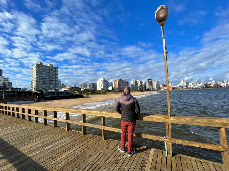 Homem observa a Playa Mansa em Punta del Este no inverno a partir de píer