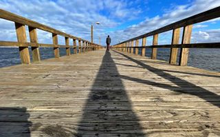 Homem de costas em píer na Playa Mansa, no Uruguai