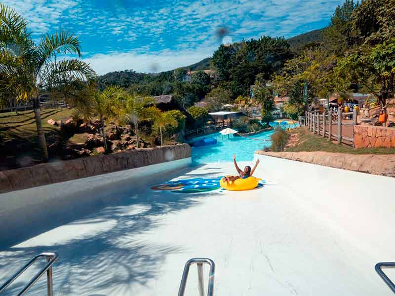 Pessoa desce de boia em toboágua do Giant Slide em dia de poucas nuvens