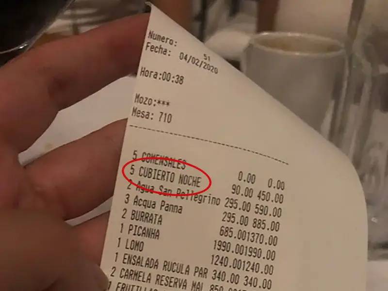 Mão segura conta em restaurante de Buenos Aires com destaque para cobrança do cubierto