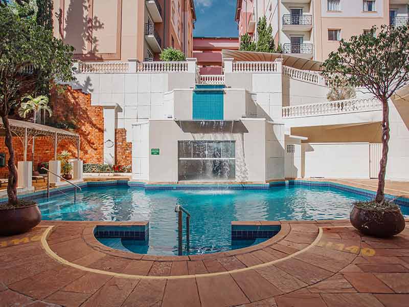 Piscina vazia do hotel Giardino com queda d'água no centro