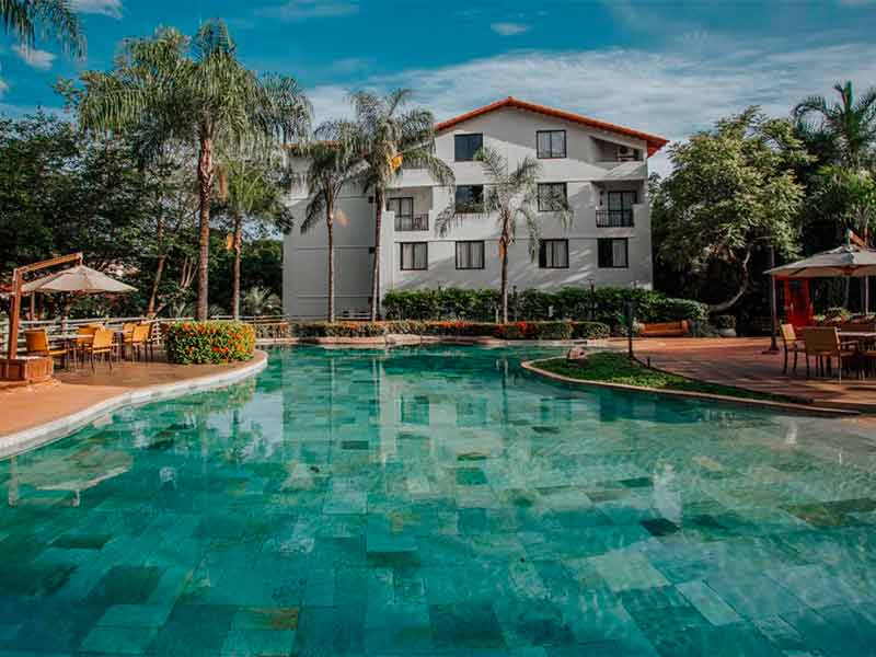 Piscina do hotel Luupi, dica de onde ficar em Rio Quente, com prédio à frente em dia de poucas nuvens