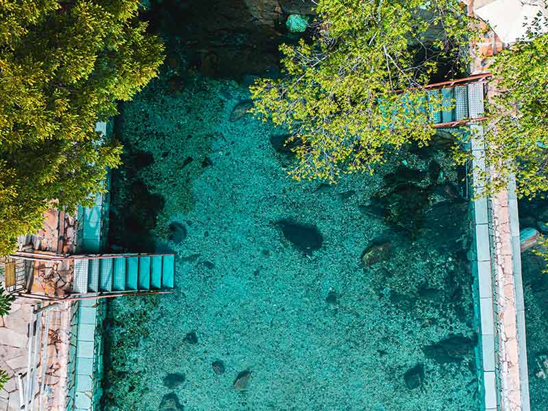 Imagem aérea do Parque das Fontes com piscina vazia e árvores ao redor