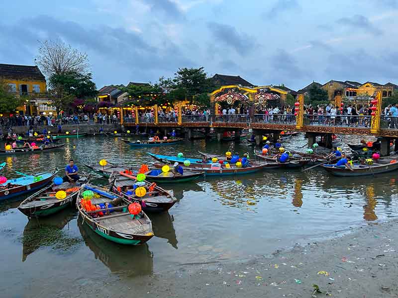 Barcos com lanternas acesas em rio de Hoi An, no Vietnã