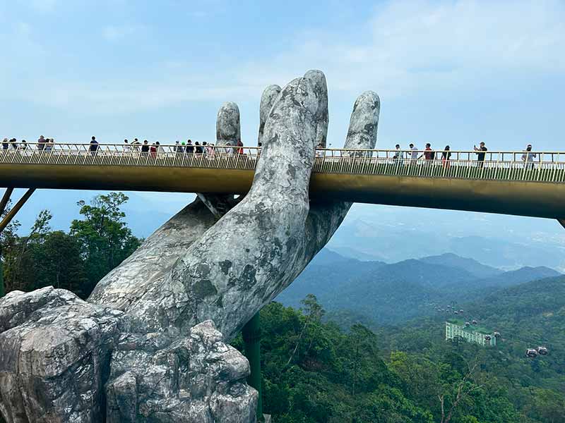 Pessoas andando pela Golden Bridge, ponte famosa pelas mãos, perto de Da Nang