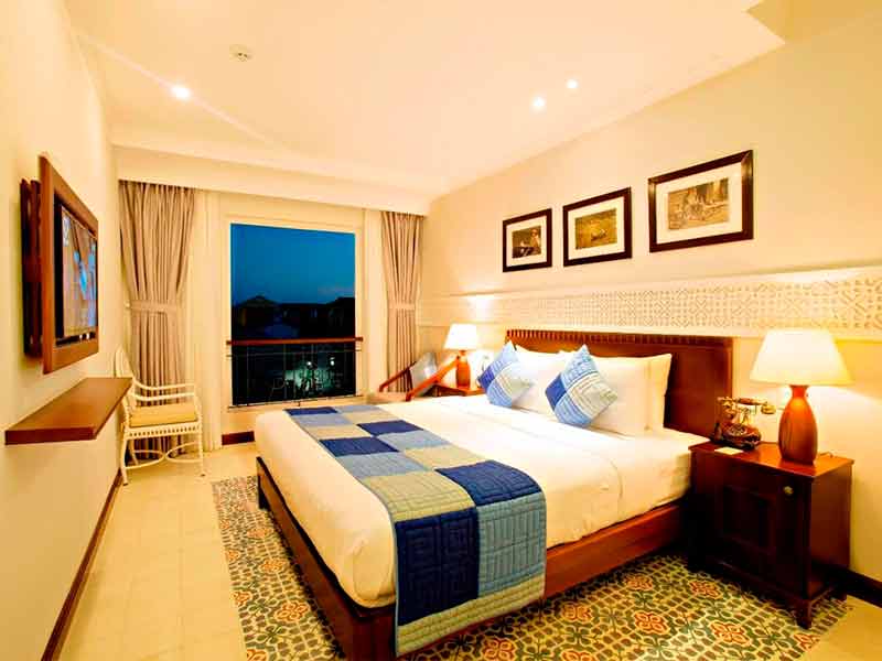 Quarto do Lantana, dica de hotel em Hoi An, com cama de casal, TV, abajur e quadros