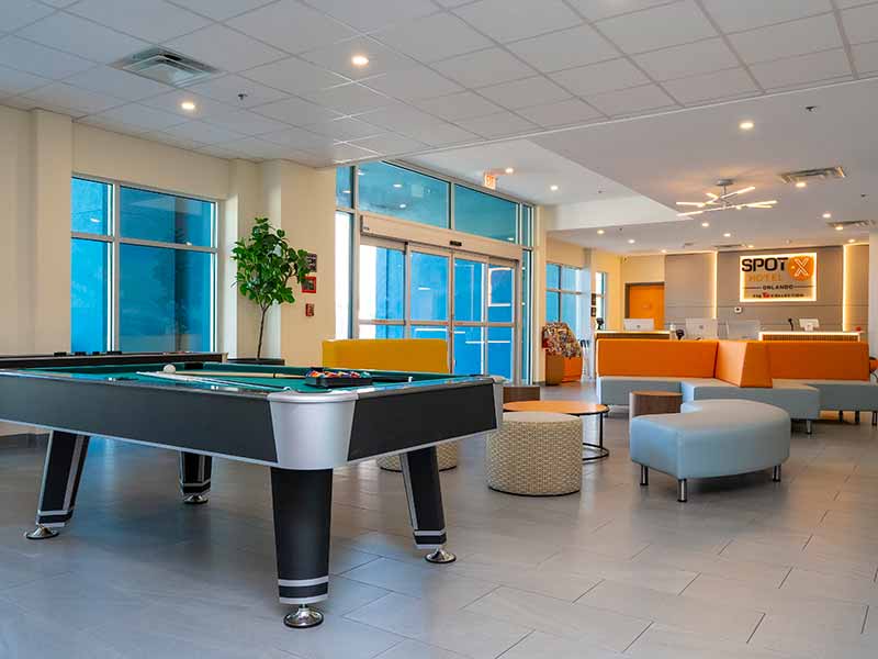 Lobby de hotel em Orlando com mesa de sinuca e sofás