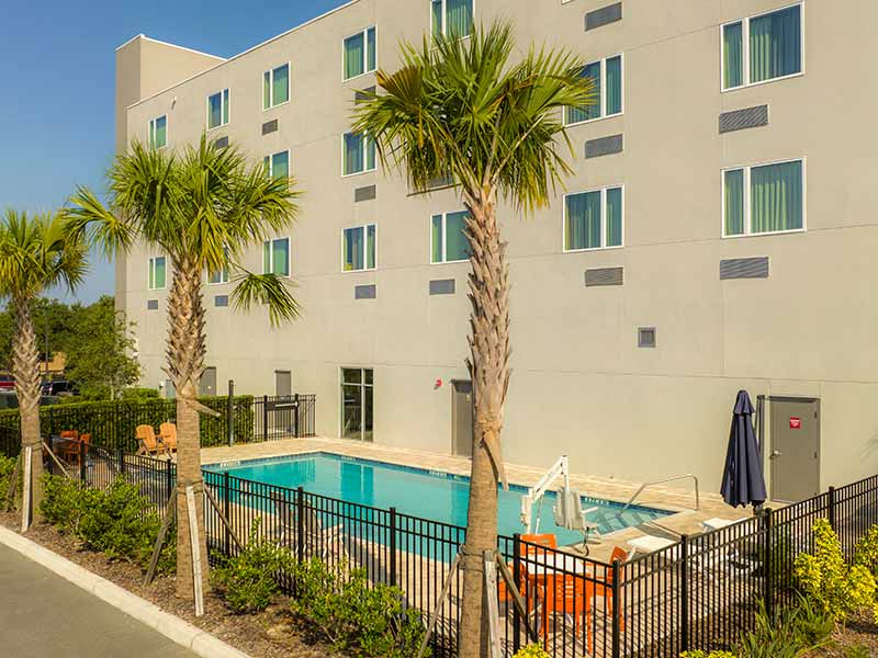 Piscina de hotel em Orlando com árvores e prédio ao lado