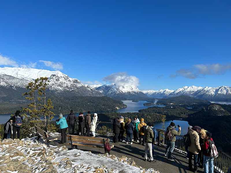 Pessoas avistam montanhas nevadas em mirante no Cerro Campanário, no Circuito Chico, em Bariloche