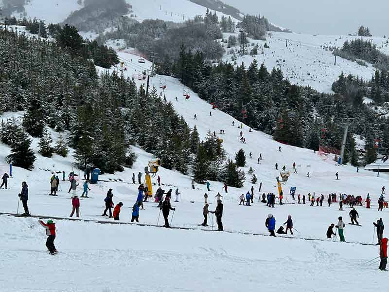 Pessoas esquiando nas montanhas cheias de neve do Cerro Catedral, em Bariloche
