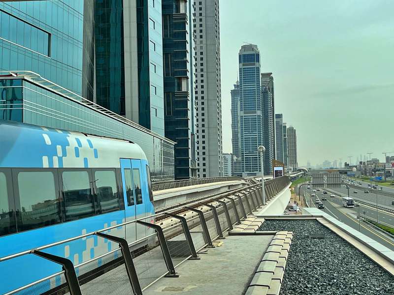 Vagão do metrô de Dubai com prédios ao fundo