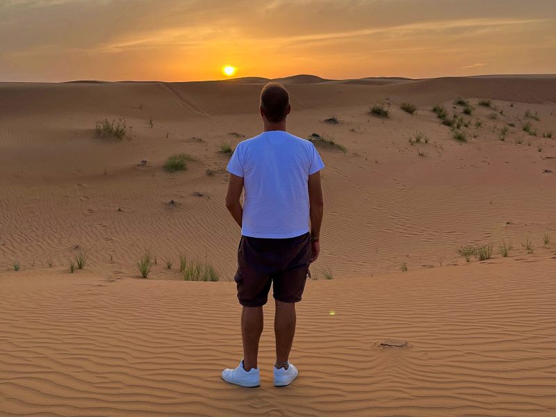 O que fazer em Dubai: Homem de costas no pôr do sol durante Safari no Deserto
