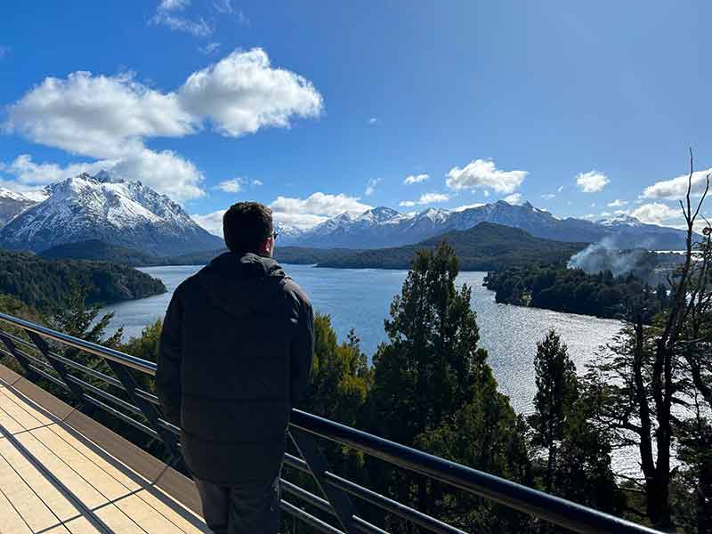 Homem de preto observa a vista do lago e das montanhas no Punto Panorâmico no Circuito Chico, em Bariloche