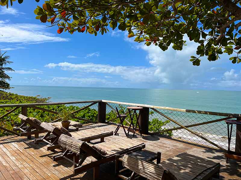 Espreguiçadeiras em deck do Armazém com a praia de Corumbau, na Bahia, à frente