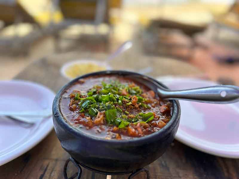 Arroz de polvo da Goinha em mesa com dois pratos no Canal do Pampo, na Bahia