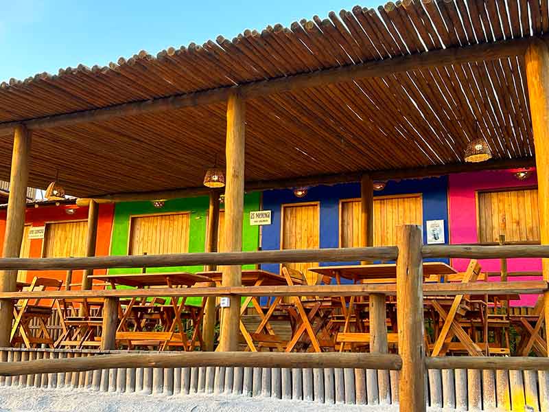 Casinhas coloridas do Comuna, restaurante que compartilha mesas em Corumbau