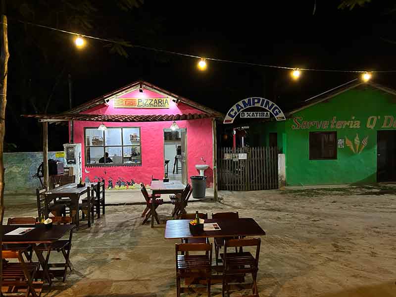 Mesas da Pizzaria Gotí na praça central de Cumuru à noite