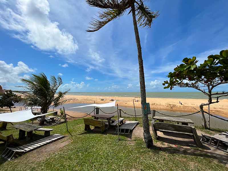 Coqueiros e mesas em jardim em frente à praia de Japara Grande, na Bahia
