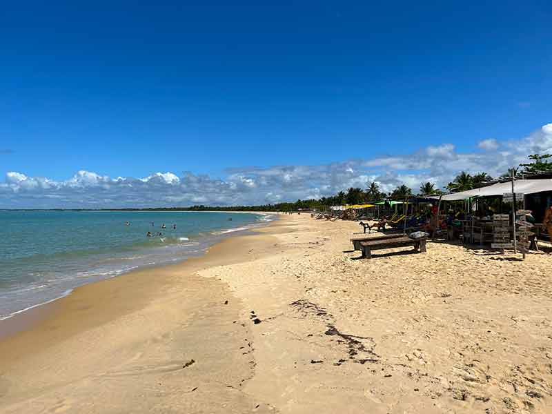 Estrutura de barracas na Ponta do Corumbau em dia de céu azul