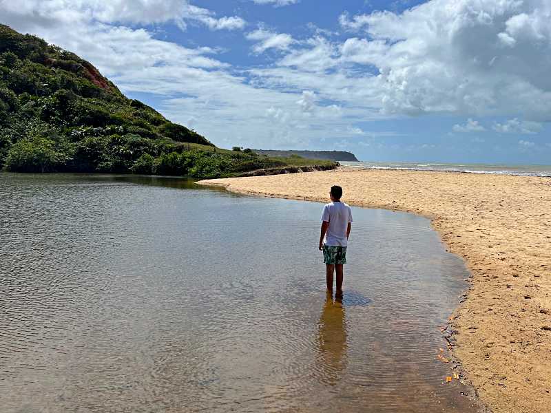 Homem de costas em pé em uma das lagoas da Praia do Satu