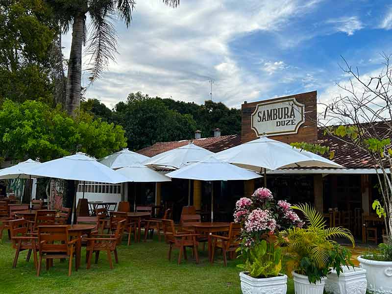 Mesas no jardim do bar Samburá Duzé no centrinho de Cumuruxatiba, na Bahia