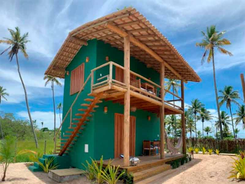 Parte externa de bangalô da Vila Budião, dica entre as pousadas na Ponta do Corumbau, em dia de céu com poucas nuvens