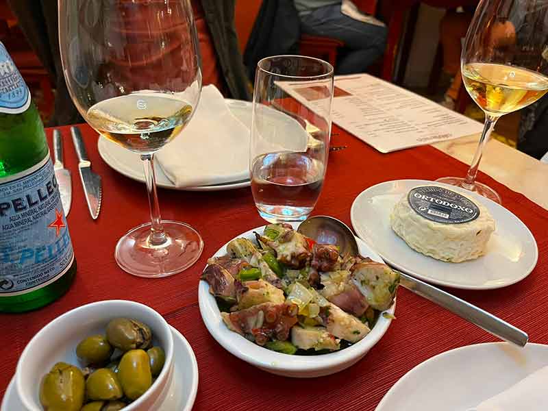 Queijo, azeitonas e coelho em mesa do Café Alentejo