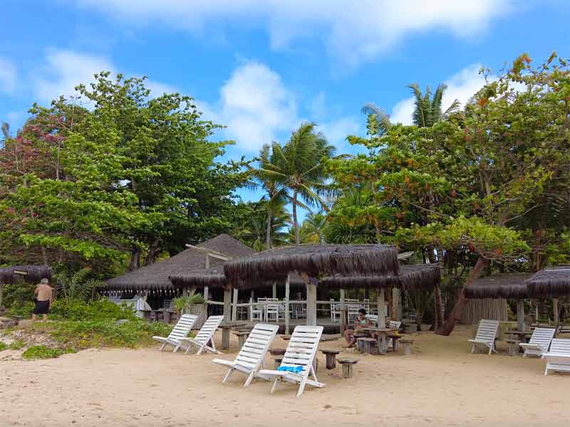 Cadeiras de praia em meio a árvores no restaurante Maria Nilza, na praia do Guaiú, na Bahia