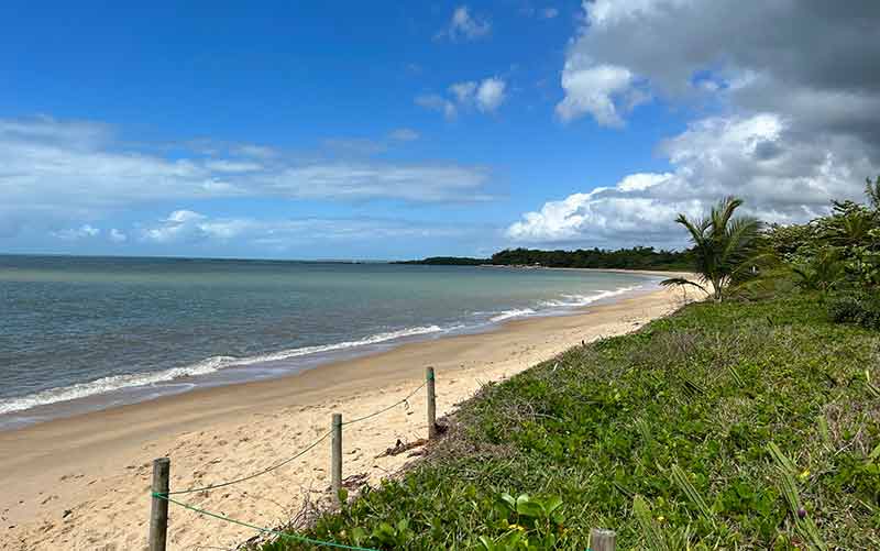 Praia de Santo André na Bahia vazia com mar com poucas ondas e vegetação verde