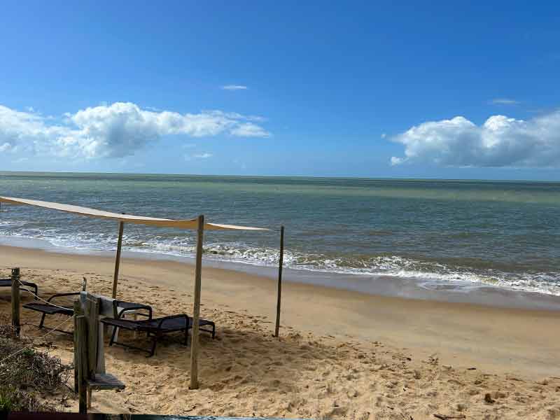 Área de praia da Pousada Victor Hugo em Santo André na Bahia em dia de céu azul