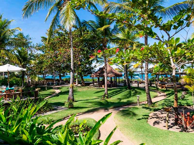 Jardim da Pousada Victor Hugo em frente à praia da vila de Santo André na Bahia