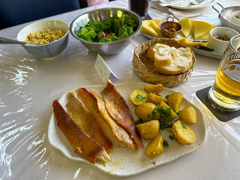 Almoço com truta defumada, batatas, arroz e salada de folhas